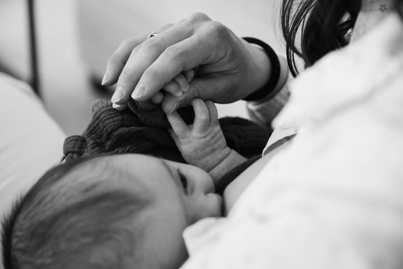 Manos de una madre y un bebé recién nacido en contacto piel con piel